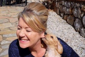A puppy biting it's owner's ear